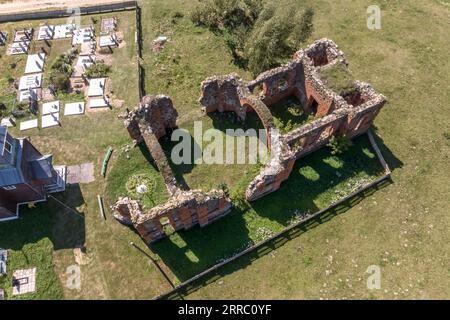 Blick aus der Luft auf verlassenen Tempel oder katholische Kirche ohne Dach auf dem Land Stockfoto