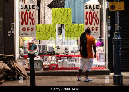 London, Großbritannien. Aug. 2023. Die Leute schauen sich einen Schaufensterladen an, auf dem in London die Aufschrift „Closing Down“ steht. (Credit Image: © May James/SOPA Images via ZUMA Press Wire) NUR REDAKTIONELLE VERWENDUNG! Nicht für kommerzielle ZWECKE! Stockfoto