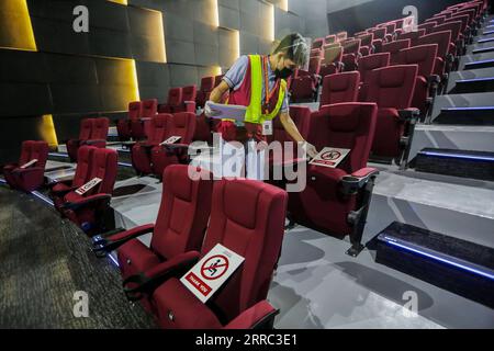 211015 -- QUEZON, 15. Oktober 2021 -- ein Mitarbeiter bringt Schilder, die an soziale Distanzierung erinnern, in einem Kino, das für die Öffentlichkeit in einem Einkaufszentrum in Quezon City, den Philippinen, am 15. Oktober 2021 wiedereröffnet wird. Die philippinische Regierung wird ab dem 16. Oktober die Lockdown-Beschränkungen in Metro Manila lockern, damit mehr öffentliche Einrichtungen in der Hauptstadt mit begrenzten Kapazitäten arbeiten können. PHILIPPINEN-QUEZON CITY-LOCKDOWN RESTRIKTIONEN ROUELLEXUMALI PUBLICATIONXNOTXINXCHN Stockfoto