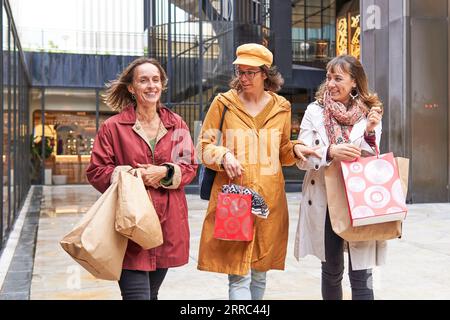 Glückliche, vielfältige Freunde des Mittelalters, die gemeinsam weihnachtseinkäufe in der Stadt genießen Stockfoto