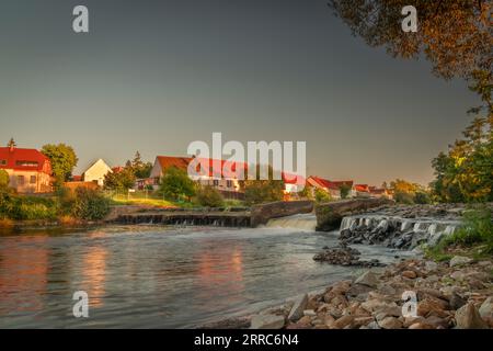 Großes Wehr in Budweis mit blauem Himmel und kleinen Gebäuden auf dem Land bei Sonnenuntergang am heißen Abend Stockfoto