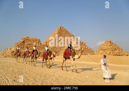 211022 -- KAIRO, 22. Oktober 2021 -- Touristen reiten auf Kamelen, um die Pyramiden von Gizeh in Gizeh, Ägypten, am 21. Oktober 2021 zu sehen. Ägypten ist in die Touristensaison eingetreten, da das Wetter kühler wird, und internationale Flüge in das Land, die aufgrund von COVID-19 ausgesetzt sind, werden allmählich wieder aufgenommen. Die Pyramiden von Gizeh werden von immer mehr Touristen besucht. ÄGYPTEN-GIZEH-PYRAMIDEN-TOURISMUS-ERHOLUNG SuixXiankai PUBLICATIONxNOTxINxCHN Stockfoto