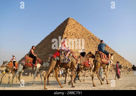 211022 -- KAIRO, 22. Oktober 2021 -- Touristen reiten auf Kamelen, um die Pyramiden von Gizeh in Gizeh, Ägypten, am 21. Oktober 2021 zu sehen. Ägypten ist in die Touristensaison eingetreten, da das Wetter kühler wird, und internationale Flüge in das Land, die aufgrund von COVID-19 ausgesetzt sind, werden allmählich wieder aufgenommen. Die Pyramiden von Gizeh werden von immer mehr Touristen besucht. ÄGYPTEN-GIZEH-PYRAMIDEN-TOURISMUS-ERHOLUNG SuixXiankai PUBLICATIONxNOTxINxCHN Stockfoto