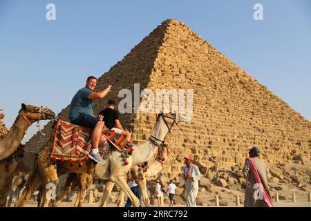 211022 -- KAIRO, 22. Oktober 2021 -- Touristen reiten auf Kamelen, um die Pyramiden von Gizeh in Gizeh, Ägypten, am 21. Oktober 2021 zu sehen. Ägypten ist in die Touristensaison eingetreten, da das Wetter kühler wird, und internationale Flüge in das Land, die aufgrund von COVID-19 ausgesetzt sind, werden allmählich wieder aufgenommen. Die Pyramiden von Gizeh werden von immer mehr Touristen besucht. ÄGYPTEN-GIZEH-PYRAMIDEN-TOURISMUS-ERHOLUNG SuixXiankai PUBLICATIONxNOTxINxCHN Stockfoto