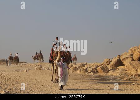 211022 -- KAIRO, 22. Oktober 2021 -- Touristen reiten auf Kamelen, um die Pyramiden von Gizeh in Gizeh, Ägypten, am 21. Oktober 2021 zu sehen. Ägypten ist in die Touristensaison eingetreten, da das Wetter kühler wird, und internationale Flüge in das Land, die aufgrund von COVID-19 ausgesetzt sind, werden allmählich wieder aufgenommen. Die Pyramiden von Gizeh werden von immer mehr Touristen besucht. ÄGYPTEN-GIZEH PYRAMIDEN-TOURISMUS-ERHOLUNG WangxDongzhen PUBLICATIONxNOTxINxCHN Stockfoto