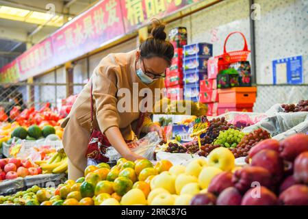 211024 -- HOHHOT, 24. Oktober 2021 -- Ein Bewohner kauft Früchte auf einem Großmarkt in Hohhot, Nordchina, Innere Mongolei Autonome Region, 24. Oktober 2021. Großhandelsmärkte für landwirtschaftliche Erzeugnisse, Supermärkte und Logistikunternehmen in Hohhot haben Maßnahmen ergriffen, um die Versorgung der Einwohner mit dem täglichen Bedarf nach dem jüngsten COVID-19-Wiederaufleben sicherzustellen. CHINA-INNERE MONGOLEI-HOHHOT-COVID-19-DAILY LIEFERT CN PENGXYUAN PUBLICATIONXNOTXINXCHN Stockfoto