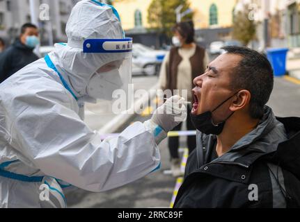 211024 -- HOHHOT, 24. Oktober 2021 -- Ein medizinischer Mitarbeiter holt eine Abstrichprobe von einem Bewohner an einem temporären Nukleinsäureteststandort in Hohhot, Nordchina, Autonome Region Innere Mongolei, 24. Oktober 2021. Um die Ausbreitung von COVID-19 einzudämmen, hat die Stadt Hohhot Nukleinsäuretests für Bewohner aus Schlüsselregionen und alle Menschen, die Hohhot mit dem Flugzeug, dem Zug, dem Shuttlebus, dem Taxi, Privatwagen und anderen Transportmitteln betreten und verlassen, eingeleitet. CHINA-INNERE MONGOLEI-HOHHOT-COVID-19-TESTSCN PENGXYUAN PUBLICATIONXNOTXINXCHN Stockfoto