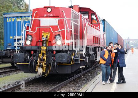 211027 -- HAMBURG, 27. Oktober 2021 -- Mitarbeiter posieren für Fotos mit dem ersten Shanghai Express in Hamburg, Deutschland, am 26. Oktober 2021. Der erste Shanghai Express mit 50 Containern, die mit Bekleidung, Autoteilen und Solarpaneelen beladen waren, fuhr mehr als 10.000 km, bevor er am späten Montag in Norddeutschland ankam. Die China-Europa-Güterzüge, die auf 73 Strecken verkehren, haben seit ihrer Einführung im Jahr 2011 mehr als 170 Städte in 23 europäischen Ländern erreicht. DEUTSCHLAND-HAMBURG-CHINA-EUROPA GÜTERZUG-ANKUNFT WANGXQING PUBLICATIONXNOTXINXCHN Stockfoto