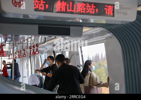 211103 -- WUHU, 3. November 2021 -- Bürger nehmen einen selbstfahrenden Zug, der auf der Einschienenbahn Linie 1 in Wuhu City, ostchinesische Provinz Anhui, 3. November 2021 fährt. Die Stadt Wuhu stellte am Mittwoch offiziell ihre erste Einschienenbahn-Linie vor, während sie versuchte, ein grünes Verkehrssystem in der Stadt zu errichten. Die Monorail-Linie 1 verkehrt in Nord-Süd-Richtung über eine Gesamtstrecke von 30,5 Kilometern mit 25 Hochbahnhöfen. Züge, die auf der Strecke fahren, können mit einer Geschwindigkeit von bis zu 80 km/h fahren. CHINA-ANHUI-WUHU-MONORAIL LINE-OPEN CN CAOXLI PUBLICATIONXNOTXINXCHN Stockfoto