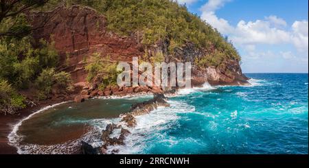 Roter Sand und blaue Wellen am Kaihalulu Beach, Hana, Maui, Hawaii, USA Stockfoto