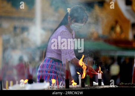 211118 -- YANGON, 18. November 2021 -- Eine Frau zündet Kerzen während des traditionellen Tazaungdaing Festivals in der Shwedagon-Pagode in Yangon, Myanmar, 18. November 2021 an. Das Tazaungdaing Festival, auch als Festival der Lichter bekannt, fällt in den achten Monat des traditionellen Myanmar-Kalenders. Es wird als Nationalfeiertag in Myanmar gefeiert. MYANMAR-YANGON-TRADITIONAL TAZAUNGDAING FESTIVAL UxAung PUBLICATIONxNOTxINxCHN Stockfoto