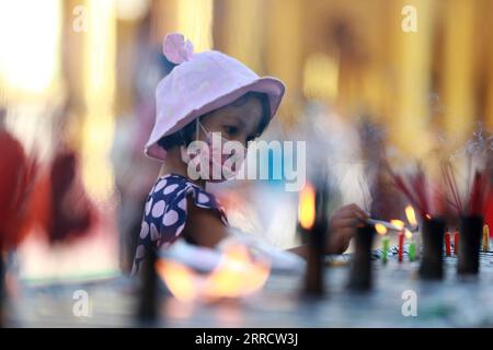 211118 -- YANGON, 18. November 2021 -- Ein Kind zündet Kerzen während des traditionellen Tazaungdaing Festivals in der Shwedagon-Pagode in Yangon, Myanmar, 18. November 2021 an. Das Tazaungdaing Festival, auch als Festival der Lichter bekannt, fällt in den achten Monat des traditionellen Myanmar-Kalenders. Es wird als Nationalfeiertag in Myanmar gefeiert. MYANMAR-YANGON-TRADITIONAL TAZAUNGDAING FESTIVAL UxAung PUBLICATIONxNOTxINxCHN Stockfoto
