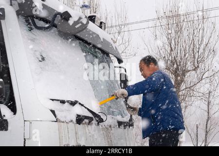 211122 -- HEGANG, 22. November 2021 -- Ein Arbeiter entfernt Schnee vom Windschild eines Schneepfluges in der Stadt Hegang, Provinz Heilongjiang im Nordosten Chinas, 22. November 2021. Schwere Schneefälle trafen in letzter Zeit viele Teile von Heilongjiang. Mitarbeiter verschiedener Sektoren trotzen eisigen Böen und Schneeflocken, um die normale Verfügbarkeit wesentlicher öffentlicher Dienste zu gewährleisten. CHINA-HEILONGJIANG-BLIZZARD CN XiexJianfei PUBLICATIONxNOTxINxCHN Stockfoto