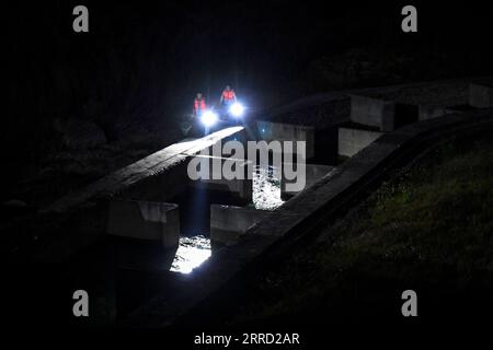 211127 -- GUIPING, 27. November 2021 -- Mitarbeiter inspizieren den Fishway des Hilfsdamms im Nanmu River, der Teil des Dateng Gorge Water Conservancy Project ist, in Guiping, südchinesische autonome Region Guangxi Zhuang, 26. November 2021. Das Wasserkraftprojekt wird auf dem Gebiet errichtet, das aufgrund seiner komplexen Strömungsbedingungen ein wichtiger Lebensraum für Fische ist. Ein seltener Doppelfischweg für den Hauptdamm und den Hilfsdamm wurde daher zu Beginn der Bauarbeiten vorgeschlagen, der wie ein künstlicher Durchgang für Wanderfische aussah. CHINA-GUANGXI-GUIPING-DATENG GORGE-ECOLOGICAL Stockfoto