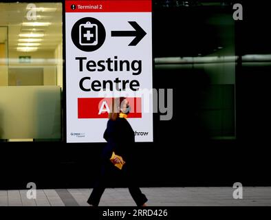 211201 -- LONDON, 1. Dezember 2021 -- Ein Passagier geht an einem Schild vorbei, auf dem das Testzentrum am Flughafen Heathrow in London, Großbritannien, am 30. November 2021 steht. Der britische Premierminister Boris Johnson sagte am Samstag, dass alle Reisenden, die nach Großbritannien einreisen, bis zum Ende des zweiten Tages nach ihrer Ankunft einen PCR-Test machen müssen und sich selbst isolieren müssen, bis sie ein negatives Testergebnis erhalten. Passagiere, die ab 0400 Uhr (GMT) am 28. November aus Ländern der roten Reiseroute Großbritanniens, einschließlich Südafrika, in Großbritannien ankommen, müssen ein von der Regierung genehmigtes Hotel buchen und bezahlen, damit es 10 Tage lang unter Quarantäne gestellt werden kann. Omicron, A Stockfoto