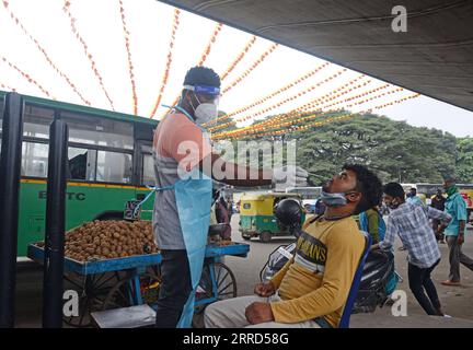 211203 -- BANGALORE, 3. Dez. 2021 -- Ein Mitarbeiter des Gesundheitswesens nimmt eine Abstrichprobe eines Reisenden für COVID-19-Tests auf einem Markt in Bangalore, Indien, 2. Dez. 2021. Indiens COVID-19-Bilanz stieg am Donnerstag auf 34.606.541 an, da in den letzten 24 Stunden im ganzen Land 9.765 neue Fälle registriert wurden, wie die jüngsten Daten des Bundesgesundheitsministeriums zeigen. STR/INDIA-COVID-19-TESTING Xinhua PUBLICATIONxNOTxINxCHN Stockfoto