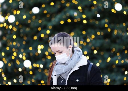 211210 -- PARIS, 10. Dezember 2021 -- Eine Frau mit Maske geht an einem riesigen Weihnachtsbaum am Vendome Place in Paris, Frankreich, 9. Dezember 2021 vorbei. Seit November 2020 wurden in Frankreich am Mittwoch täglich 61.340 neue COVID-19-Fälle bestätigt, die in den letzten 24 Stunden bestätigt wurden. Damit steigt die kumulative Zahl der COVID-19-Fälle im Land auf 8.048.931. FRANCE-PARIS-COVID-19 GaoxJing PUBLICATIONxNOTxINxCHN Stockfoto