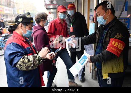 211210 -- HANGZHOU, 10. Dezember 2021 -- Ein Freiwilliger überprüft Gesundheitsvorschriften und Körpertemperaturen am Eingang eines Marktes in Hangzhou, Ostchinesische Provinz Zhejiang, 10. Dezember 2021. Acht Stadtviertel von Hangzhou haben öffentliche Plätze, darunter Bibliotheken, Museen, Theater und Internetcafés, gebeten, die Besucherzahl auf nicht mehr als die Hälfte ihrer Gesamtkapazität zu beschränken. CHINA-ZHEJIANG-COVID-19-NUKLEINSÄURETEST CN HUANGXZONGZHI PUBLICATIONXNOTXINXCHN Stockfoto