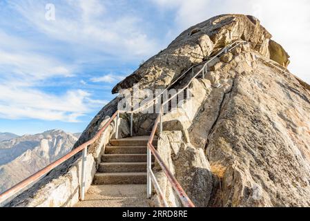 Eine Treppe führt an einem sonnigen Herbsttag auf einen felsigen Berggipfel Stockfoto