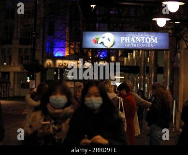 211213 -- LONDON, 13. Dezember 2021 -- Menschen mit Masken warten auf den Eintritt in das her Majesty's Theatre, wo das Musical The Phantom of the Opera gezeigt wurde, in London, Großbritannien, 12. Dezember 2021. Die COVID-19-Alarmstufe in Großbritannien wurde von Stufe 3 auf Stufe 4 erhöht, da die Zahl der Fälle in Omicron rasch zunahm , sagte der britische Chief Medical Officer in einer gemeinsamen Erklärung am Sonntag. GROSSBRITANNIEN-LONDON-COVID-19-ALARMSTUFE LixYing PUBLICATIONxNOTxINxCHN Stockfoto