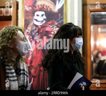 211213 -- LONDON, 13. Dezember 2021 -- Menschen mit Masken warten darauf, das her Majesty's Theatre in London, Großbritannien, 12. Dezember 2021 zu betreten. Die COVID-19-Alarmstufe in Großbritannien wurde von Stufe 3 auf Stufe 4 erhöht, da die Zahl der Fälle in Omicron rasch zunahm , sagte der britische Chief Medical Officer in einer gemeinsamen Erklärung am Sonntag. GROSSBRITANNIEN-LONDON-COVID-19-ALARMSTUFE LixYing PUBLICATIONxNOTxINxCHN Stockfoto