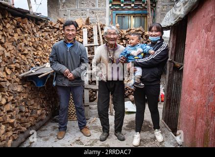 211214 -- LHASA, 14. Dezember 2021 -- Chodar 2nd L posiert am 24. November 2021 für ein Foto mit seinen Familienmitgliedern in der Grafschaft Dinggye in Xigaze, Südwestchinas Autonome Region Tibet. Chodar, 86, war einst ein Sklave, der ein elendes Leben führte. Er floh mit 17 Jahren aus seinem Dorf, weil er die Unterdrückung des Leibeigentümers nicht ertragen konnte. Nach der demokratischen Reform in Tibet im Jahr 1959 haben in seiner Heimatstadt große Veränderungen stattgefunden. Im Alter von 35 Jahren kehrte er in sein Dorf zurück. Nach der demokratischen Reform gibt es keine Unterdrückung mehr durch Sklavenhalter, und wir haben Ackerland für Pflanzen und Rinder und Stockfoto