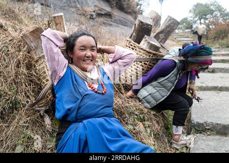 211214 -- LHASA, 14. Dezember 2021 -- Sherpa-Frauen tragen Vorräte bergauf in Zhentang Stadt Xigaze, Südwestchina autonome Region Tibet, 24. November 2021. Tief im Himalaya gelegen, ist eine kleine Stadt namens Zhentang im tibetischen Dinggye County eine der Siedlungen für die Sherpa. Die Grenzstadt hat eine durchschnittliche Höhe von 2.000 Metern. In den letzten Jahren haben in Zhentang große Veränderungen stattgefunden. Eine Reihe von Infrastrukturprojekten wurde in Betrieb genommen. Darüber hinaus konzentriert sich Zhentang auch auf die Entwicklung des grenzüberschreitenden Handels, der Aquakultur, des Tourismus und der Verarbeitungsindustrie mit lokalen Meisterleistungen Stockfoto