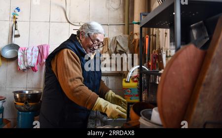 211215 -- LHASA, 15. Dezember 2021 -- Tsering Drolma bereitet sich auf das Mittagessen in ihrem Haus in Lhasa, der autonomen Region Tibet im Südwesten Chinas, am 7. Dezember 2021 vor. Tsering Drolma, geboren 1940, ist ein Rentner, der in der Stadt Lhasa lebt. Sie war einst Leibeigene und führte ein elendes Leben in der Kindheit. Im Alter von 8 Jahren war sie zu jung, um schwere Arbeiten zu verrichten, so dass sie nur wenige Rationen von der Leichenbesitzerin verdienen konnte. Abgesehen vom Hunger musste sie die Kälte ertragen, als ihr Leibeigentümer sie nachts im Freien mit Vieh schlafen ließ. Was für eine felicity es war, jeden Tag etwas früher in der Sonne zu baden. Die Sonne ist unvoreingenommen Stockfoto