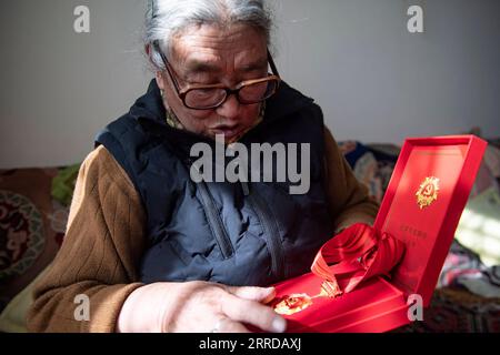 211215 -- LHASA, 15. Dezember 2021 -- Tsering Drolma zeigt ihre Gedenkmedaille an diejenigen, die seit fünf Jahrzehnten Mitglieder der Kommunistischen Partei Chinas sind, in Lhasa, Südwestchinas autonomer Region Tibet, 7. Dezember 2021. Tsering Drolma, geboren 1940, ist ein Rentner, der in der Stadt Lhasa lebt. Sie war einst Leibeigene und führte ein elendes Leben in der Kindheit. Im Alter von 8 Jahren war sie zu jung, um schwere Arbeiten zu verrichten, so dass sie nur wenige Rationen von der Leichenbesitzerin verdienen konnte. Abgesehen vom Hunger musste sie die Kälte ertragen, als ihr Leibeigentümer sie nachts im Freien mit Vieh schlafen ließ. Was für eine Stockfoto