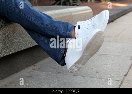 Weiße Tennisschuhe sind ein Basic, das Mode und Trends im Laufe der Geschichte überholt hat. Zu Fuß, zur Arbeit oder einfach zu Hause zu sein Stockfoto