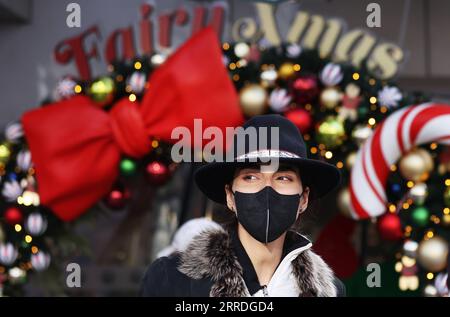 News Bilder des Tages Coronavirus, Eindrücke aus Paris 211224 -- PARIS, 24. Dezember 2021 -- Eine Frau mit Gesichtsmaske spaziert auf der Champs Elysees Avenue in Paris, Frankreich, 23. Dezember 2021. FRANCE-PARIS-COVID-19-DAILY LIFE GaoxJing PUBLICATIONxNOTxINxCHN Stockfoto