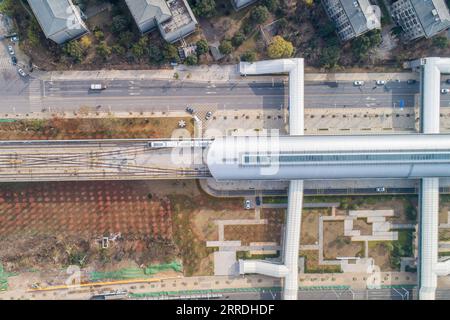 211226 -- WUHAN, 26. Dezember 2021 -- Luftaufnahme vom 26. Dezember 2021 zeigt einen Zug, der von der Hubei University of Chinese Medicine Station der U-Bahn-Linie 5 in Wuhan, der zentralchinesischen Provinz Hubei, abfährt. Drei Stadtbahnlinien in Wuhan wurden am Sonntag für die Öffentlichkeit geöffnet – Linie 5, die zweite Phase der Linie 6, und Linie 16 Hannan mit einer Gesamtlänge von 75,2 km Linie 5 ist Wuhans erste vollautomatische U-Bahn-Linie. Die Linie 16 wird entlang des Yangtze gebaut, mit der höchsten Station auf 30 Metern, die den Passagieren eine schöne Aussicht bietet. Die Gesamtlänge der in Wuhan in Betrieb befindlichen U-Bahn-Schienen beträgt Stockfoto