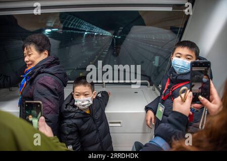 211226 -- WUHAN, 26. Dezember 2021 -- Passagiere posieren für Fotos auf der ersten Kutsche eines Zuges der Metro-Linie 5 in Wuhan, Zentralchinas Provinz Hubei, 26. Dezember 2021. Drei Stadtbahnlinien in Wuhan wurden am Sonntag für die Öffentlichkeit geöffnet – Linie 5, die zweite Phase der Linie 6, und Linie 16 Hannan mit einer Gesamtlänge von 75,2 km Linie 5 ist Wuhans erste vollautomatische U-Bahn-Linie. Die Linie 16 wird entlang des Yangtze gebaut, mit der höchsten Station auf 30 Metern, die den Passagieren eine schöne Aussicht bietet. Die Gesamtlänge der in Wuhan in Betrieb befindlichen U-Bahn-Schienen hat 435 km erreicht Foto von /Xinhua CHINA- Stockfoto