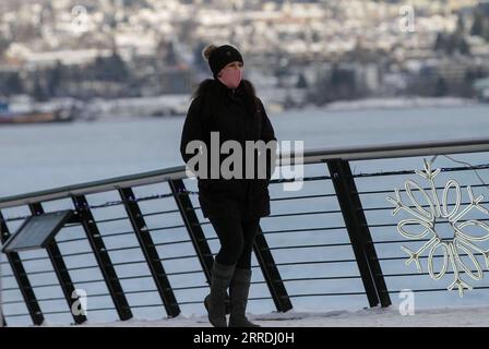 211227 -- VANCOUVER, 27. Dezember 2021 -- Eine Frau, die Eine Gesichtsmaske trägt, spaziert am 27. Dezember 2021 in der Nähe des Canada Place in Vancouver, British Columbia, Kanada. Kanada meldete am Montagmittag 18.230 neue COVID-19-Fälle, wodurch das kumulative ganze laut CTV auf 2.026.249 Fälle mit 30.172 Todesfällen angehoben wurde. Foto: /Xinhua CANADA-VANCOUVER-COVID-19-CASES-2 MLN LiangxSen PUBLICATIONxNOTxINxCHN Stockfoto