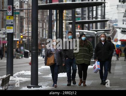 211227 -- VANCOUVER, 27. Dezember 2021 -- Menschen mit Gesichtsmasken gehen am 27. Dezember 2021 auf einer Straße in Vancouver, British Columbia, Kanada. Kanada meldete am Montagmittag 18.230 neue COVID-19-Fälle, wodurch das kumulative ganze laut CTV auf 2.026.249 Fälle mit 30.172 Todesfällen angehoben wurde. Foto: /Xinhua CANADA-VANCOUVER-COVID-19-CASES-2 MLN LiangxSen PUBLICATIONxNOTxINxCHN Stockfoto