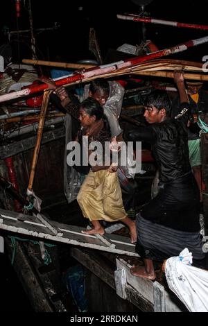 211231 -- ACEH, 31. Dezember 2021 -- Rohingya-Flüchtlinge laufen von einem Holzboot, während indonesische Beamte im Hafen Krueng Geukueh in Lhokseumawe, Aceh, Indonesien, am 31. Dezember 2021 evakuieren. Die indonesische Marine hat mehr als 100 Rohingya-Asylsuchende gerettet, die auf einem sinkenden Boot vor der Westküste des Landes herumgerissen sind und sie an einen vorübergehenden Ort gebracht haben. Foto von /Xinhua INDONESIA-ACEH-ROHINGYA-REFUGEES-EVAKUATION FachrulxReza PUBLICATIONxNOTxINxCHN Stockfoto