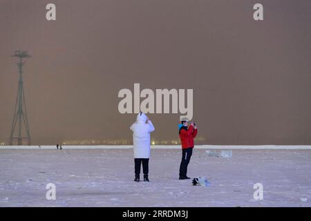 220102 -- HARBIN, 2. Januar 2022 -- Menschen machen Fotos auf dem gefrorenen Songhua-Fluss nach einem Schneefall in Harbin, nordöstliche Provinz Heilongjiang, 1. Januar 2022. CHINA-HEILONGJIANG-HARBIN-SNOWFALL CN XiexJianfei PUBLICATIONxNOTxINxCHN Stockfoto