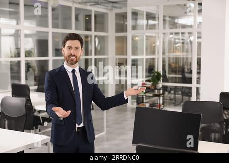 Selbstbewusster männlicher Immobilienmakler im Amt Stockfoto