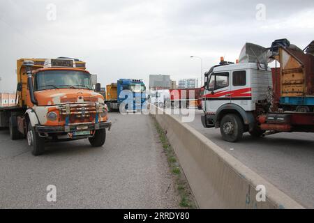 220113 -- TRIPOLI, 13. Januar 2022 -- Lkw-Fahrer blockieren die Straße Tripoli-Beirut während eines Protestes am 13. Januar 2022 am Eingang nach Tripoli im Libanon. Am Donnerstag fand ein landesweiter Protest gegen die steigenden Preise und die Verschlechterung der Lebensbedingungen statt, die durch die langfristige Wirtschaftskrise verursacht wurden. Fahrer und Bürger gingen auf die Straßen der Hauptstadt Beirut, Tripoli, Khalde und anderer Städte und Städte, parkten ihre Autos in der Mitte der Straßen und verbrannten Staubbehälter, um die Hauptstraßen zu blockieren. Foto von /Xinhua LEBANON-ECONOMY-PROTEST KhaledxHabashiti PUBLICATIONxNOTxINxCHN Stockfoto