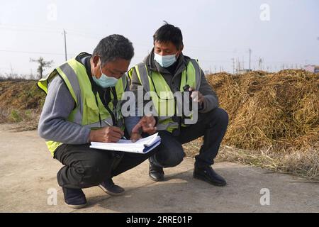 220115 -- NANCHANG, 15. Januar 2022 -- Arbeiter berechnen die Anzahl der Zugvögel auf einem Reisfeld im Yugan County, ostchinesische Provinz Jiangxi, 11. Januar 2022. Der Poyang Lake, der größte Süßwassersee des Landes, ist ein wichtiger Überwinterungsort für Zugvögel. Um die Futtervorräte für die Vögel zu erhöhen, erließ die lokale Regierung des Yugan County 2021 eine Entschädigungspolitik für Landwirte und reservierte Reis für Zugvögel. Im fünf-Sterne-Sibirischen Kranichheiligtum Nanchang am Poyang-See wurden Kraniche auf einem Lotussee zum Essen angezogen. Der Teich, initiierte und investierte mich Stockfoto