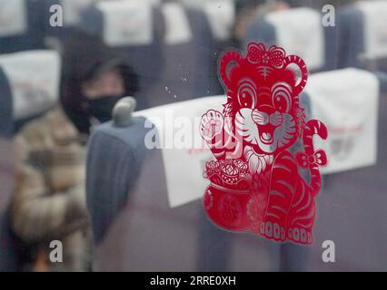 220117 -- PEKING, 17. Januar 2022 -- Ein Papier schneidendes Kunstwerk wird auf ein Fenster des Zuges G6737 am Beijing West Railway Station in Peking, Hauptstadt von China, 17. Januar 2022 eingefügt. Die Reisezeit des chinesischen Frühjahrsfestes 2022 wird voraussichtlich 1,18 Milliarden Passagierfahrten mit sich bringen, ein Anstieg von 35,6 Prozent im Vergleich zum Jahr, aber 20,3 Prozent weniger als im Jahr 2020, so das Verkehrsministerium. Die 40-tägige Reisezeit, auch bekannt als Chunyun, begann am Montag, und viele Menschen werden reisen, um sich mit ihren Familien zum Mondneujahr oder zum Frühlingsfest, das dieses Jahr am 1. Februar stattfindet, wiederzuvereinigen. CHINA-FEDER F Stockfoto