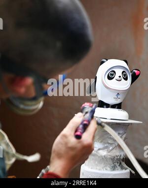 220119 -- DEHUA, 19. Januar 2022 -- Ein Arbeiter arbeitet an einer Porzellanfigur von Bing Dwen Dwen, dem Maskottchen der Olympischen Winterspiele 2022 in Peking, in einer Porzellanfabrik im Bezirk Dehua von Quanzhou, Provinz Fujian im Südosten Chinas, 19. Januar 2022. CHINA-FUJIAN-BEIJING 2022 MASKOTTCHEN-PORZELLAN CN WEIXPEIQUAN PUBLICATIONXNOTXINXCHN Stockfoto