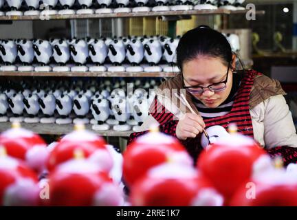 220119 -- DEHUA, 19. Januar 2022 -- Ein Arbeiter färbt Porzellanfiguren von Peking 2022 Maskottchen in einer Porzellanfabrik in Dehua County von Quanzhou, südöstliche Provinz Fujian, 19. Januar 2022. CHINA-FUJIAN-BEIJING 2022 MASKOTTCHEN-PORZELLAN CN WEIXPEIQUAN PUBLICATIONXNOTXINXCHN Stockfoto