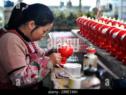 220119 -- DEHUA, 19. Januar 2022 -- Ein Arbeiter färbt eine Porzellanfigur von Shuey Rhon Rhon, dem Maskottchen der Paralympischen Winterspiele 2022 in Peking, in einer Porzellanfabrik in Dehua County Quanzhou, Provinz Fujian im Südosten Chinas, 19. Januar 2022. CHINA-FUJIAN-BEIJING 2022 MASKOTTCHEN-PORZELLAN CN WEIXPEIQUAN PUBLICATIONXNOTXINXCHN Stockfoto