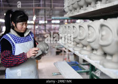 220119 -- DEHUA, 19. Januar 2022 -- Ein Arbeiter arbeitet an einer halbfertigen Porzellanfigur von Bing Dwen Dwen, dem Maskottchen der Olympischen Winterspiele 2022 in Peking, in einer Porzellanfabrik in Dehua County Quanzhou, Provinz Fujian im Südosten Chinas, 19. Januar 2022. CHINA-FUJIAN-BEIJING 2022 MASKOTTCHEN-PORZELLAN CN WEIXPEIQUAN PUBLICATIONXNOTXINXCHN Stockfoto