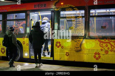 220208 -- TORONTO, 8. Februar 2022 -- Passagiere steigen in einen Bus mit einem Design, das das Mondneujahr des Tigers feiert, an einer Bushaltestelle in Toronto, Kanada, 7. Februar 2022. Die Toronto Transit Commission TTC nahm an der Feier des Lunar New Year Teil, indem sie eine Reihe von Fahrzeugen einpackte, die vom 1. Bis 15. Februar dieses Jahres in Betrieb sein sollten. Foto von /Xinhua CANADA-TORONTO-TTC-LUNAR NEUJAHRSFEIER ZouxZheng PUBLICATIONxNOTxINxCHN Stockfoto