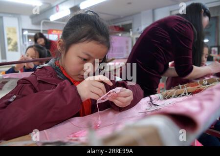 220211 -- NANCHANG, 11. Februar 2022 -- Ein Kind lernt, das Muster von Bing Dwen Dwen zu sticken, dem Maskottchen für die Olympischen Winterspiele 2022 in Peking, im Bezirk Donghu der Stadt Nanchang in der ostchinesischen Provinz Jiangxi, 10. Februar 2022. CHINA-JIANGXI-NANCHANG-BING DWEN-STICKEREI CN PENGXZHAOZHI PUBLICATIONXNOTXINXCHN Stockfoto