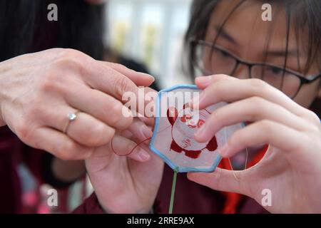 220211 -- NANCHANG, 11. Februar 2022 -- Ein Kind lernt, das Muster von Bing Dwen Dwen zu sticken, dem Maskottchen für die Olympischen Winterspiele 2022 in Peking, im Bezirk Donghu der Stadt Nanchang in der ostchinesischen Provinz Jiangxi, 10. Februar 2022. CHINA-JIANGXI-NANCHANG-BING DWEN-STICKEREI CN PENGXZHAOZHI PUBLICATIONXNOTXINXCHN Stockfoto