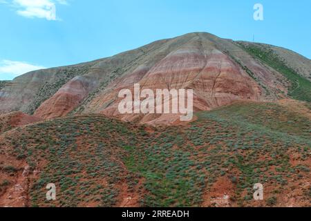 Blick auf die leuchtend roten sandig-tonigen Hänge des Berges Big Bogdo. Eine einzigartige natürliche Formation in der Nähe des Salzsees Baskunchak. Russland. Stockfoto