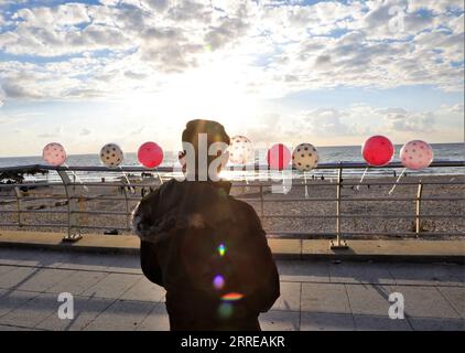 220214 -- BEIRUT, 14. Februar 2022 -- Ein junger Mann verkauft Ballons am Valentinstag an der Küste von Beirut, Libanon, am 14. Februar 2022. LEBANON-BEIRUT-VALENTINE S DAY LiuxZongya PUBLICATIONxNOTxINxCHN Stockfoto